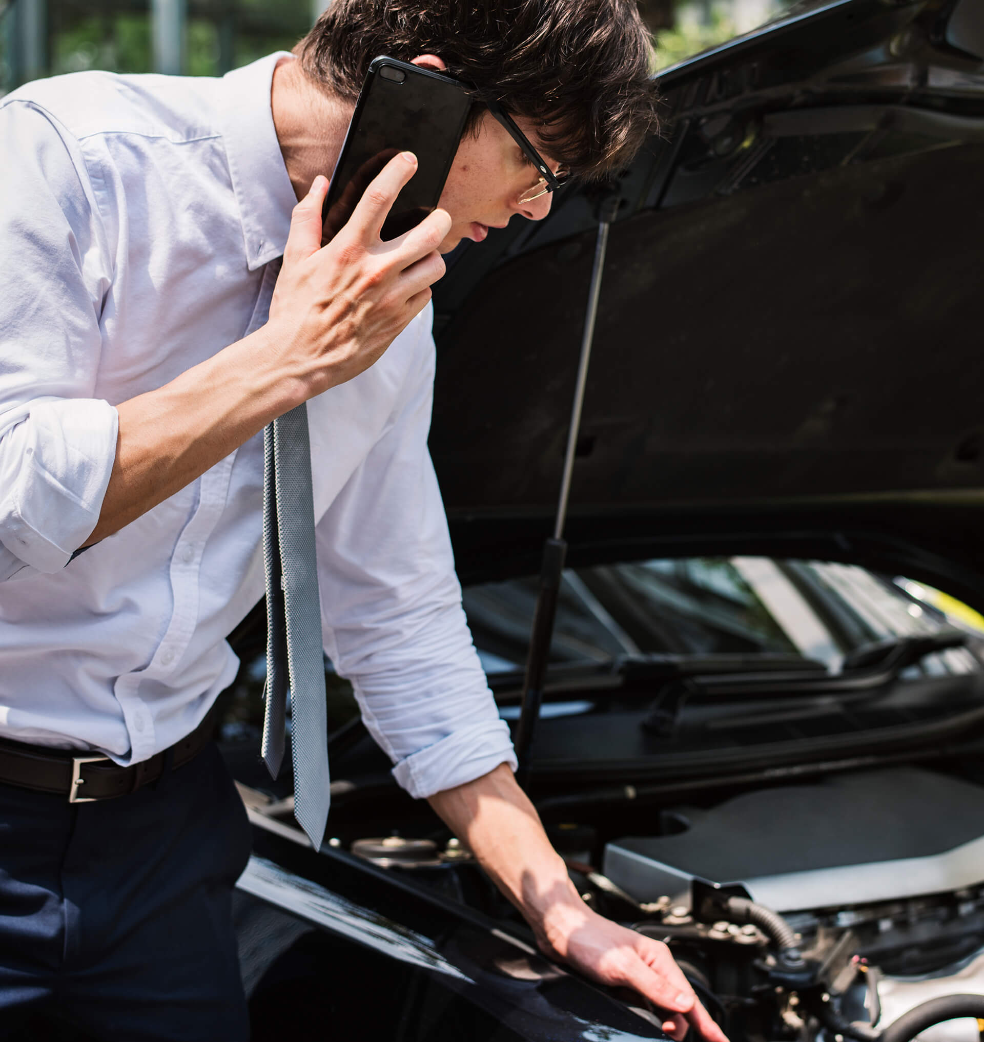 Regular Maintenance with guy examining the inside of the car whilst being on the phone