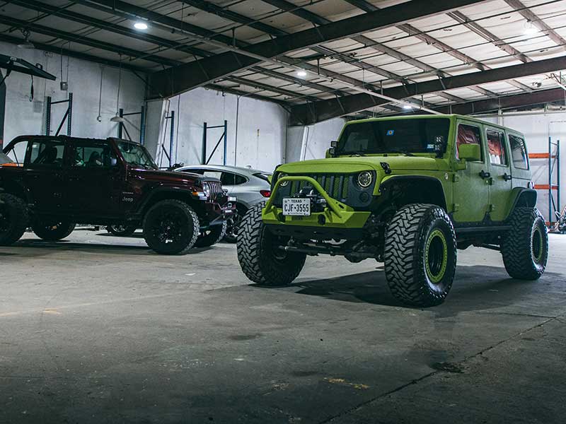 Protective Finish shown on a green Jeep, which is inside of a workshop